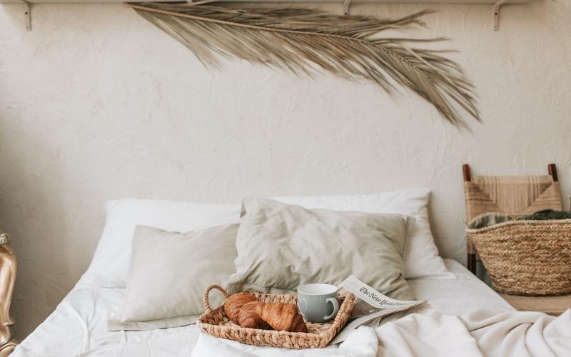a bed with a cup of coffee and a book on it