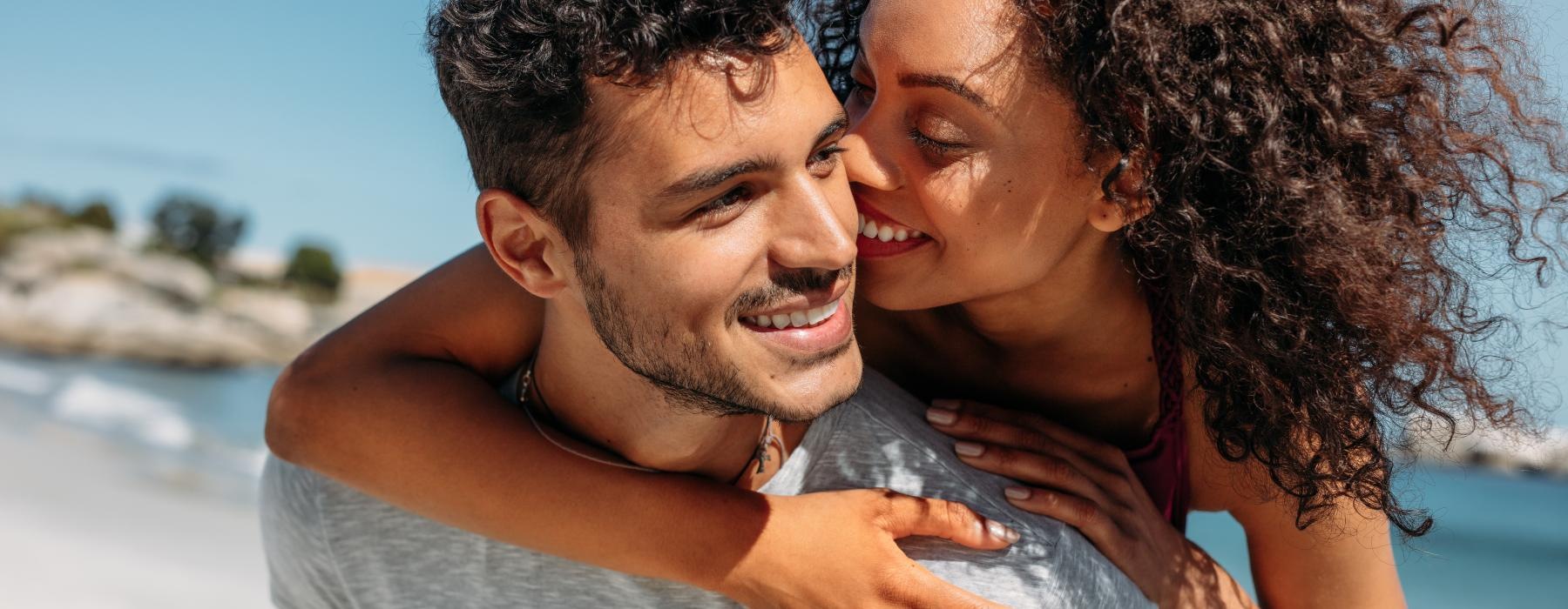 a man and woman embracing on a beach